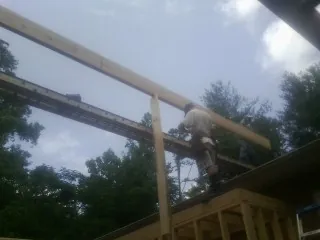 Carpenter setting a ridge beam over a new addition frame — Ice Dam Removal by Roofing Brothers in Stockdale