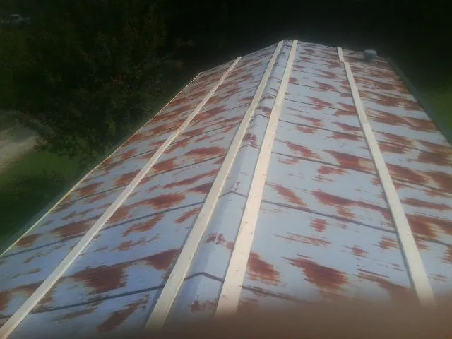 Rusted metal roof panels with new wood purlins before replacement — Storm Damage Roof Repair in Stockdale by Roofing Brothers