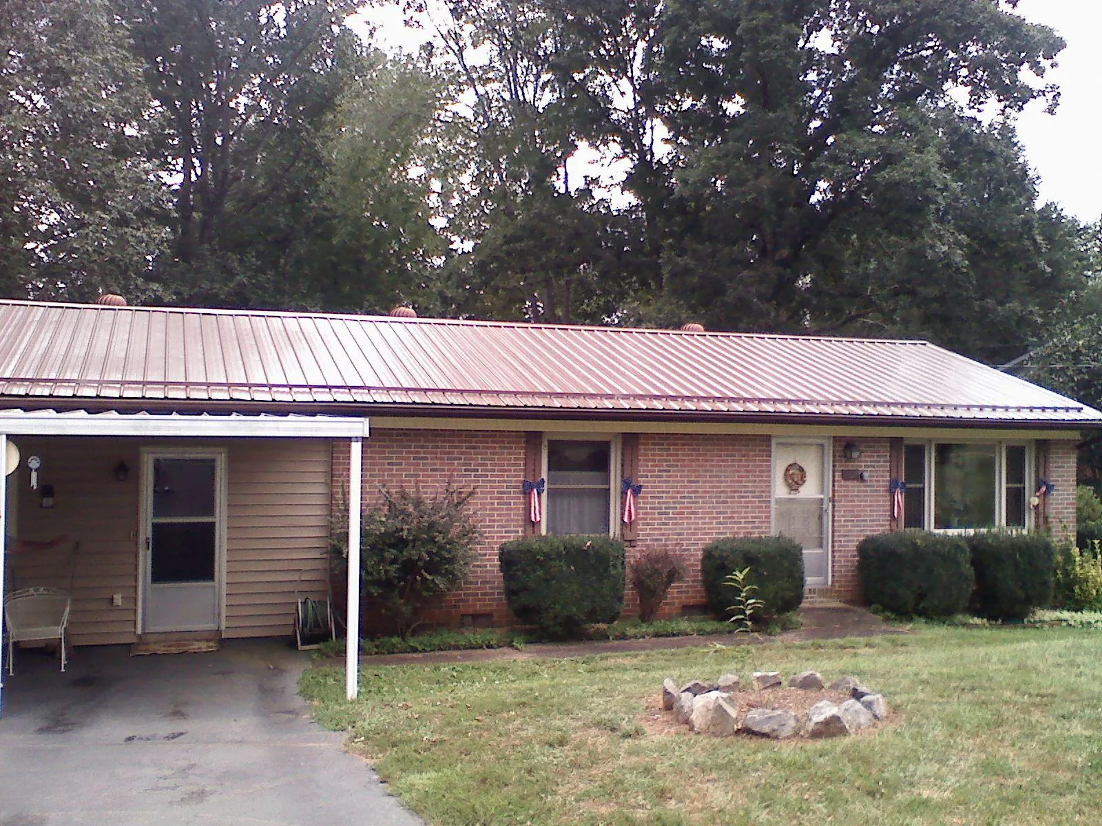Bronze metal roof and carport on a brick ranch home — Roof Repair work by our crew in Stockdale
